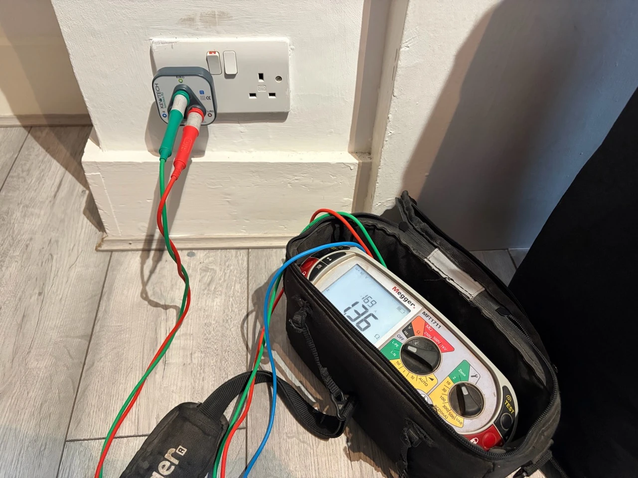 Electrical test instrument connected to a socket during inspection