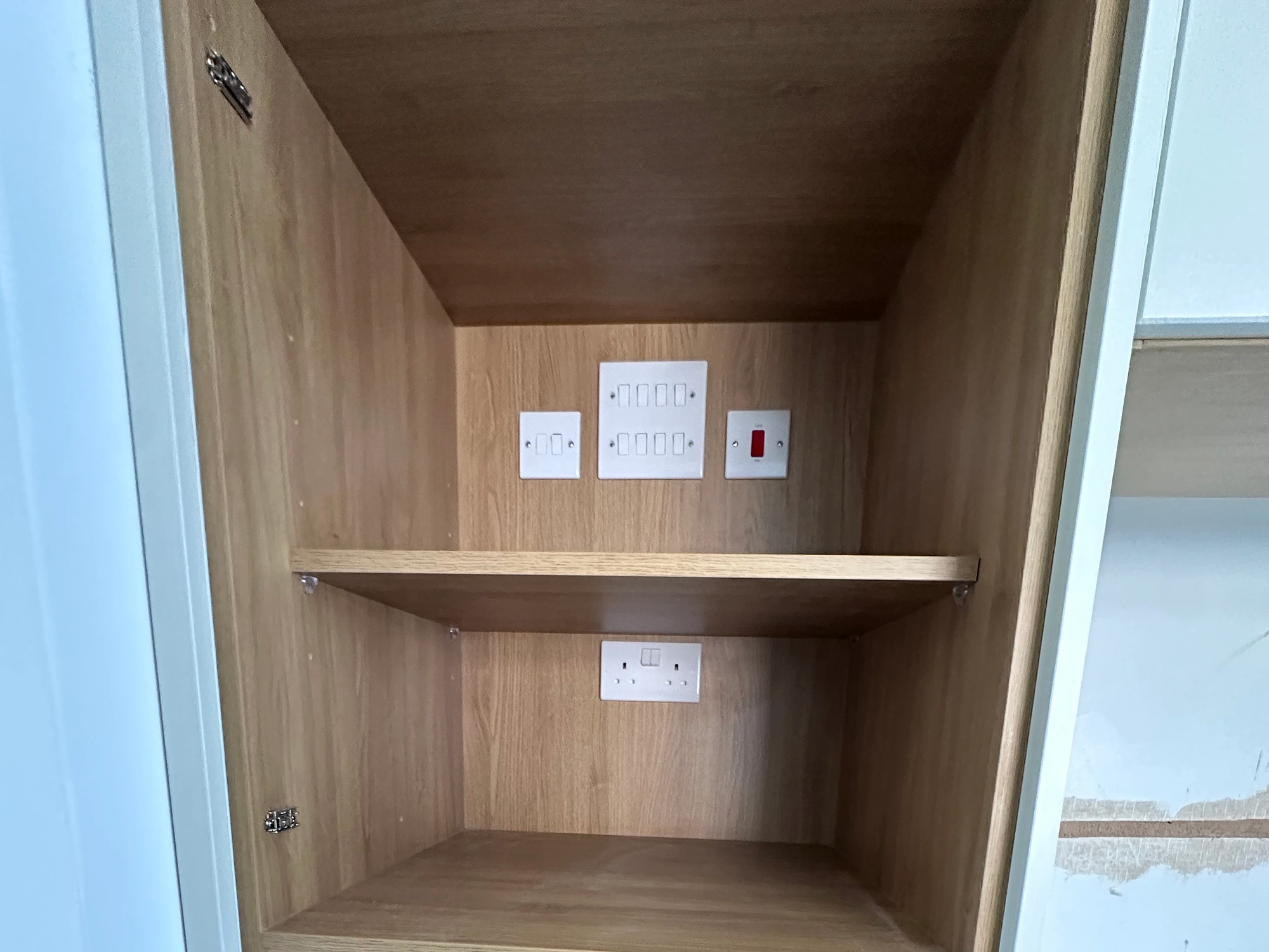 Neatly positioned electrical controls and socket outlets inside fitted North London joinery