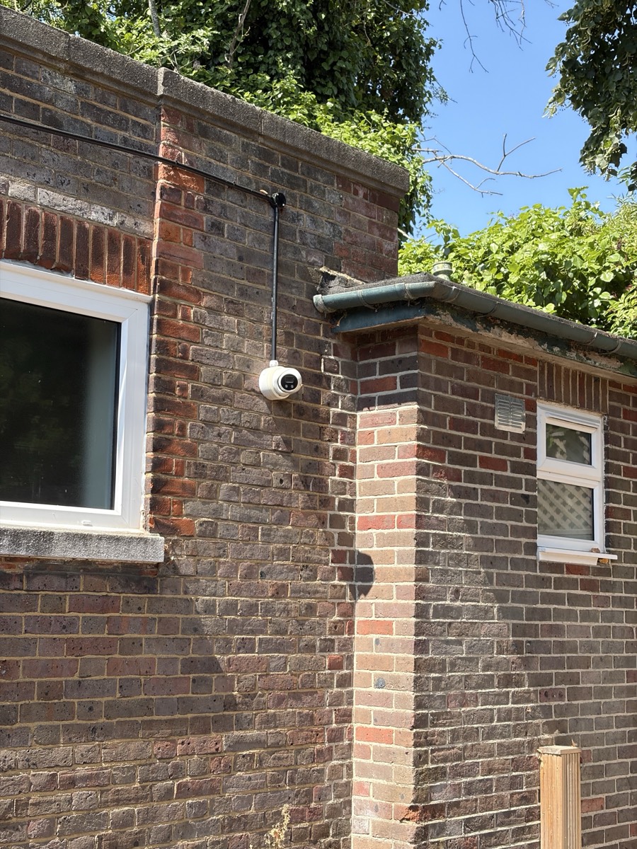 Hikvision exterior CCTV camera installed on a brick wall in Enfield