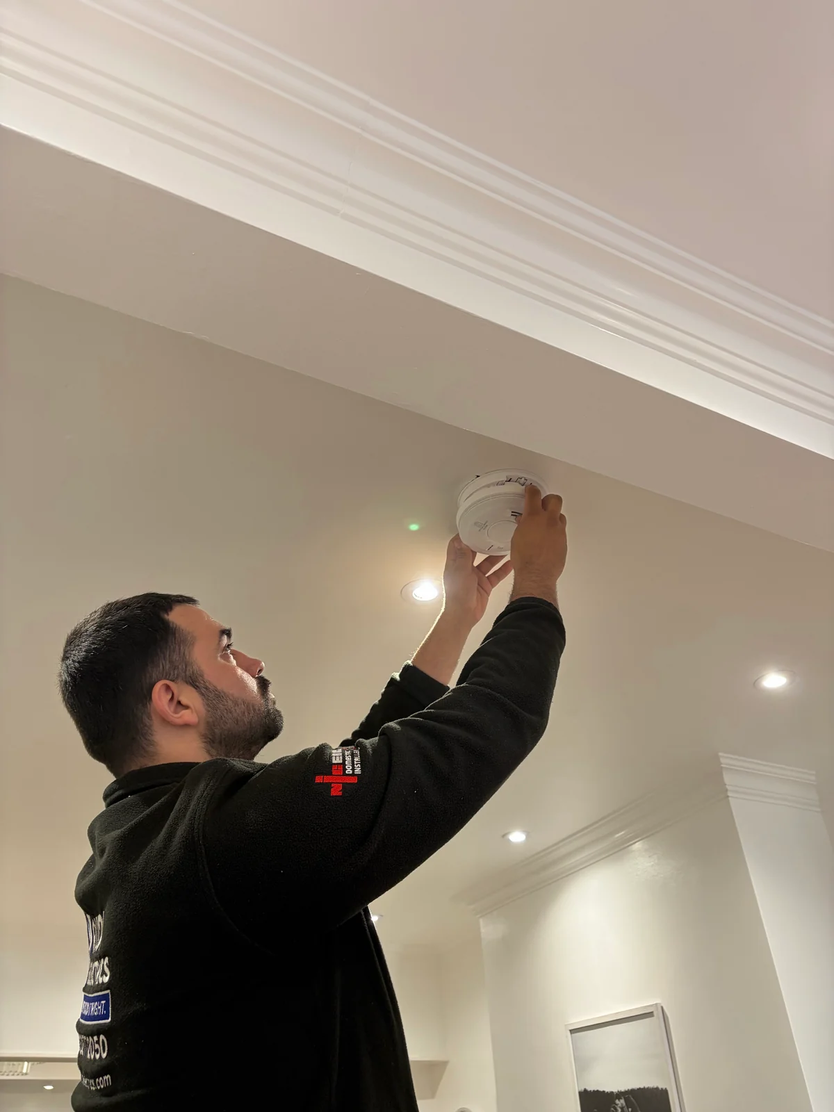 Rudi changing a smoke alarm in a North London home