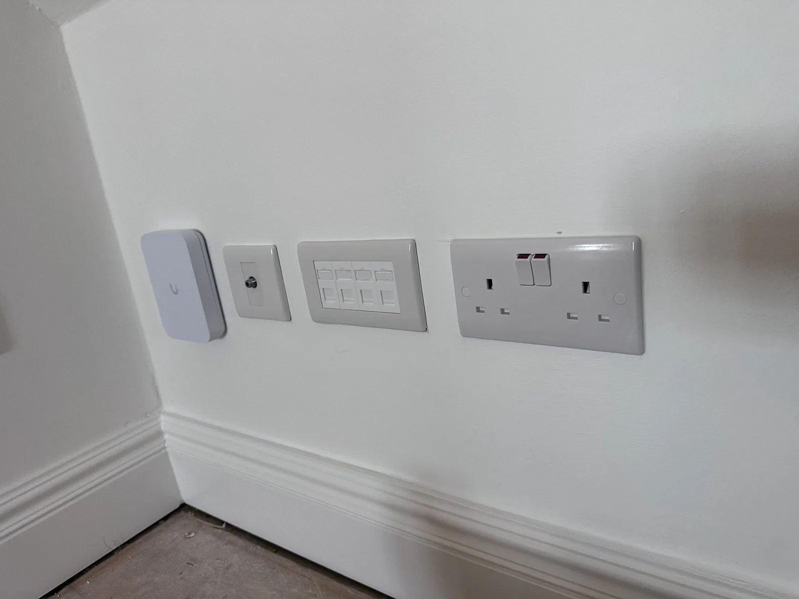 Ubiquiti access point, Cat6 data outlets and power sockets installed together in a North London home