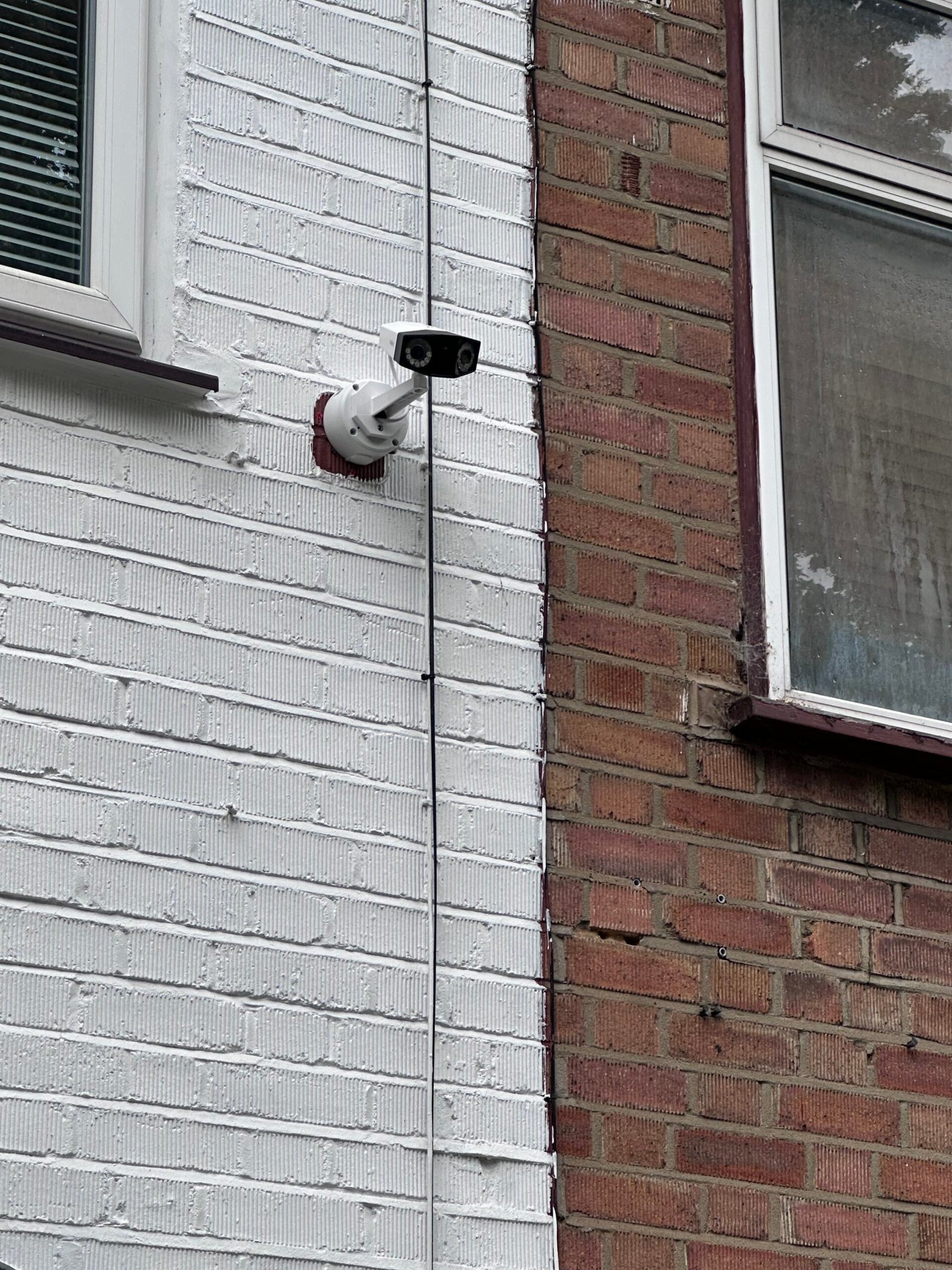 CCTV bullet camera on rendered wall — North London